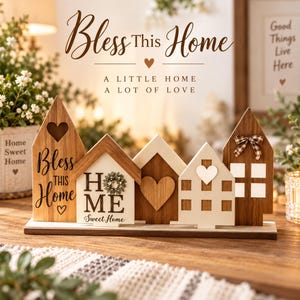 Puede incluir: Un expositor de mesa decorativo de madera con cinco siluetas en forma de casa sobre una base rectangular. Las piezas tienen acabados en madera natural y blanco, corazones recortados, una pequeña corona, un lazo de cuadros y el texto Bless This Home.