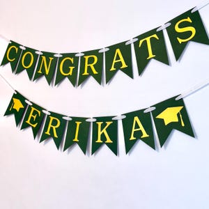 May include: Green and gold graduation banner with the text "Congrats Erika".