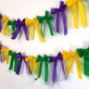 May include: A Mardi Gras party garland with green, purple, and gold bows and tulle. The garland is perfect for decorating for a Mardi Gras party.