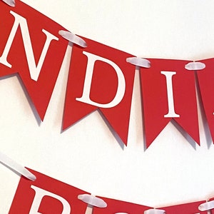 May include: Red and white banner with the word "INDIVIDUALLY" printed on it. The banner is made of paper and has white string attached to each end.
