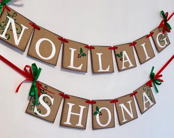May include: A brown paper banner with the words "Nollaig Shona" in white letters. The banner is decorated with green holly leaves and red berries. The banner is strung with red ribbon and green bows.