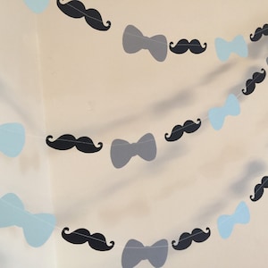 May include: A garland with alternating blue bow ties and black mustaches. The garland is perfect for a party or celebration.