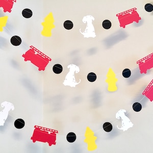 May include: A red, white and black paper garland featuring fire engines, dalmatian dogs and fire hydrants. The garland is strung together with black circles.