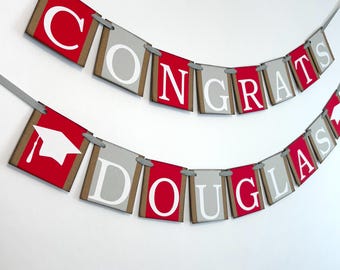 May include: Red and gray graduation banner with the text "Congrats Douglas" and a graduation cap.
