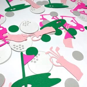 May include: Pink and green golf themed confetti. The confetti includes golf balls, golf clubs, golf carts, and flags. The confetti is perfect for a golf themed party.
