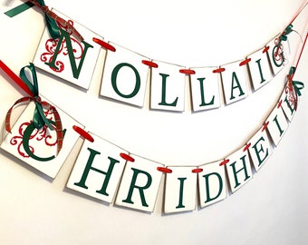 May include: A white banner with red and green ribbon, spelling out "Nollaig Chridheil" in green letters. The banner is perfect for decorating for the holidays.