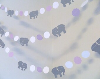 May include: A garland with alternating white circles, purple circles with scalloped edges, and gray elephant cutouts. The garland is strung together with white thread.