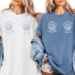 May include: A white ceramic mug with a black handle and the text "But First, Coffee" in a bold, black font. The mug is set against a blurred background, suggesting a cozy setting.