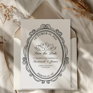 May include: A formal wedding invitation with a black ornate frame and the text "October 10, 2026 Save the Date" featuring two swans. The invitation is in a white envelope, with the names Savannah & James and Asheville, NC.