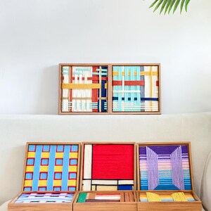 K&ouml;nnte beinhalten: Eine Sammlung von f&uuml;nf quadratischen Holzrahmen mit kunstvollen Wandbildern aus Garn. Die Designs zeigen Webmuster in leuchtenden Farben wie Rot, Gelb, Blau, Violett und Wei&szlig;. Der Text "LIBRE VOYAGE" ist in der unteren rechten Ecke zu sehen.