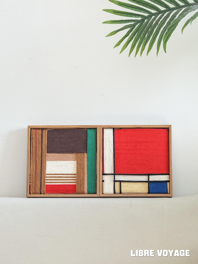 K&ouml;nnte beinhalten: Zwei quadratische Holzrahmen mit geometrischer Wandkunst aus fest gewickeltem Garn. Das linke St&uuml;ck zeigt braune, beige, wei&szlig;e, gr&uuml;ne und rote Streifen. Das rechte St&uuml;ck zeigt ein Gitter aus roten, wei&szlig;en, beigen, blauen und schwarzen Garnlinien.