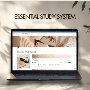 May include: A laptop displaying the "Essential Study System" Notion template. The screen shows a webpage with text and images. Sunglasses and a book are on the screen. The text "Essential Study System" and "Notion Template" are at the top.