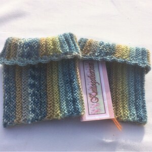 May include: A pair of knitted leg warmers in blue, green, and brown stripes. The leg warmers are folded over at the top and have a crocheted edge. A pink tag with the text "Vintagedelicious" is attached to the leg warmers.