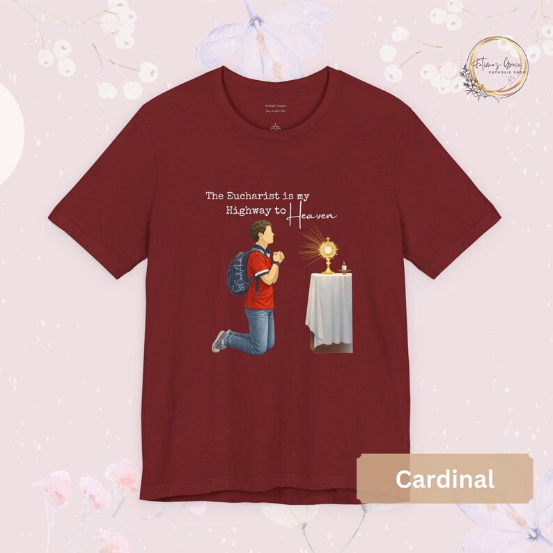 Unisex Bella and Canvas Catholic t-shirt featuring Saint Carlo Acutis kneeling in Eucharistic Adoration with the quote “The Eucharist is my Highway to Heaven,” Christian faith apparel for men and women. Perfect for Catholic gifts.