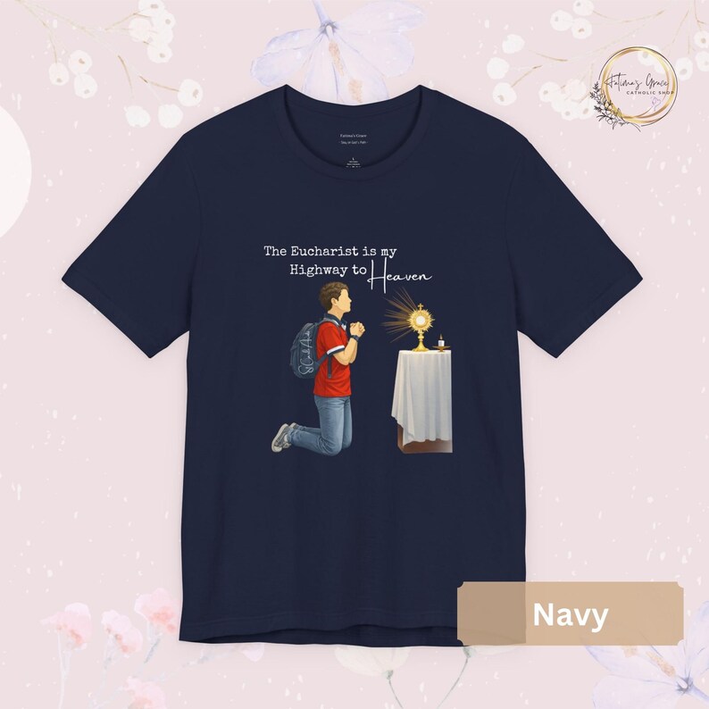 Unisex Bella and Canvas Catholic t-shirt featuring Saint Carlo Acutis kneeling in Eucharistic Adoration with the quote “The Eucharist is my Highway to Heaven,” Christian faith apparel for men and women. Perfect for Catholic gifts.