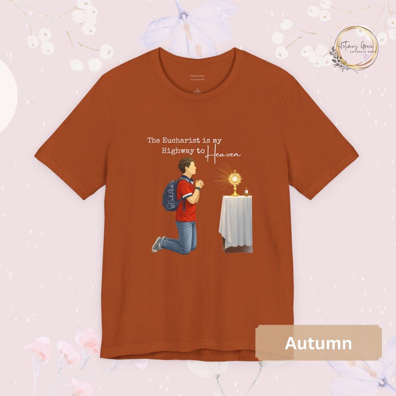 Unisex Bella and Canvas Catholic t-shirt featuring Saint Carlo Acutis kneeling in Eucharistic Adoration with the quote “The Eucharist is my Highway to Heaven,” Christian faith apparel for men and women. Perfect for Catholic gifts.