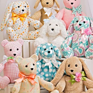 May include: A collection of eight plush stuffed animals including bears and rabbits made from various patterned fabrics like polka dots, gingham, and alphabet prints. Each toy features a ribbon bow at the neck, some with small fabric flowers attached.