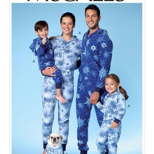 May include: McCall's pattern for matching family pajamas. The pajamas are blue with a snowflake design. The image shows a family of four and a dog wearing the pajamas. The pattern number is M7518.