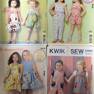 May include: Four sewing pattern envelopes from Ellie Mae Designs and Kwik Sew featuring illustrations of children wearing various rompers, jumpsuits, and dresses with floral, gingham, and striped patterns, including text labels like Sweetie Pie Rompers.