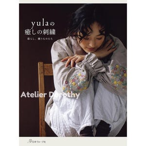 May include: A book cover with Japanese text and the title "yula's Healing Embroidery." The cover features a woman in a light-colored outfit with embroidered sleeves. The text "Atelier Dorothy" is also visible.