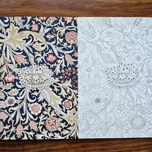 May include: Two floral patterned papers. One features a dark navy background with cream, gold, red, and peach-colored flowers and leaves. The other is a black and white line drawing of the same floral pattern.