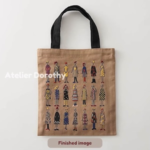 Könnte beinhalten: Beige Tragetasche mit schwarzen Henkeln, bestickt mit Figuren in verschiedenen Outfits. Der Text "Atelier Dorothy" befindet sich links, und "Finished image" unten. Ein stilvolles Accessoire.
