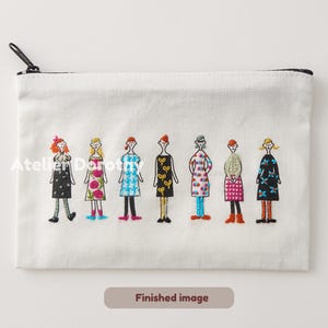 Könnte beinhalten: Eine weiße Canvas-Reißverschlusstasche mit einem gestickten Design von sieben Figuren in Kleidern. Jede Figur hat ein einzigartiges Kleidmuster und Farbschema. Die Tasche hat einen schwarzen Reißverschluss und den Text "Finished image".