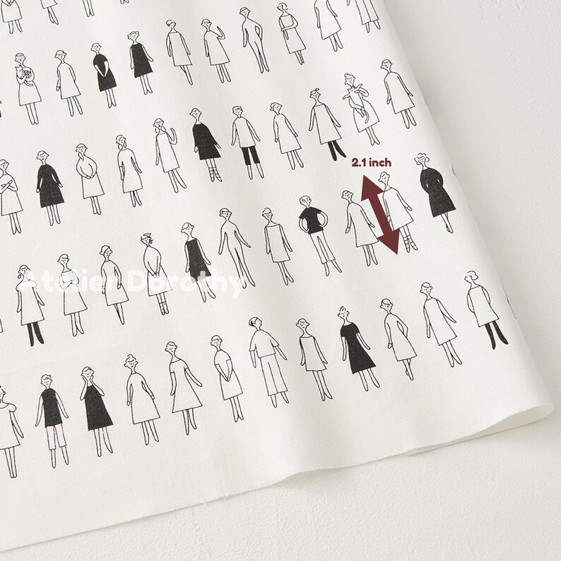 May include: White fabric with a repeating pattern of stylized figures in black. The figures are dressed in various outfits. A red arrow indicates a measurement of 2.1 inches.