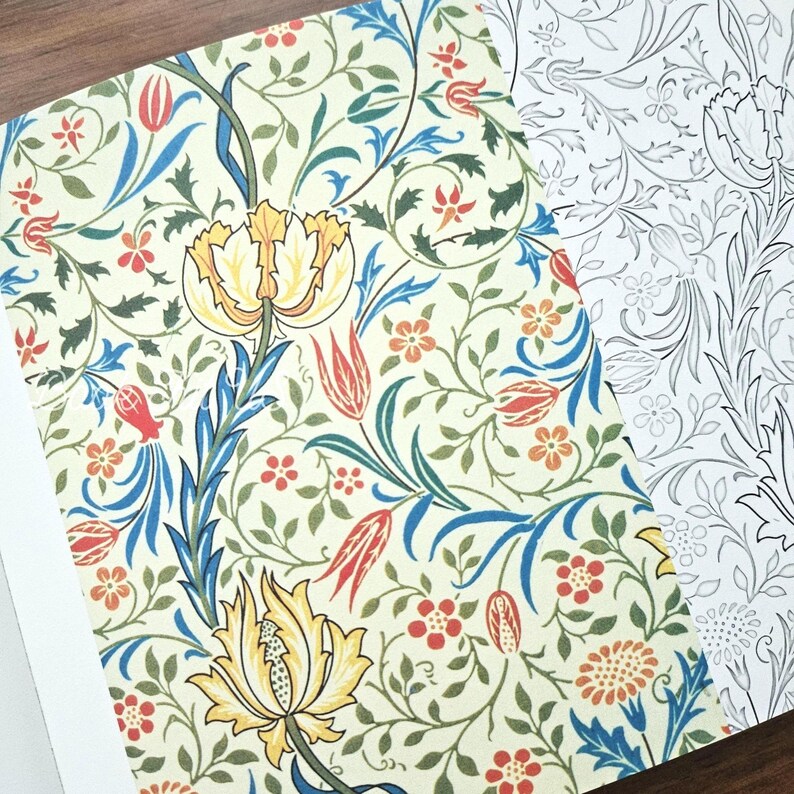 May include: Open book pages featuring a floral pattern. The design includes yellow, red, and orange flowers with green leaves and blue stems on a cream background. The adjacent page shows a black and white outline of the same floral design.