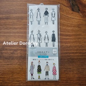 May include: A white fabric panel featuring line drawings of figures in various outfits. The panel includes Japanese text and the words "Atelier Dorothy" in the corner. The fabric is packaged in a clear plastic bag.
