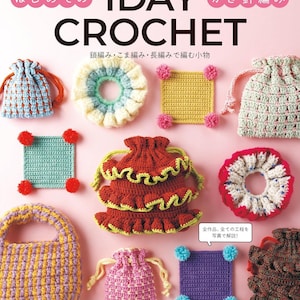 Puede incluir: Una portada de libro de manualidades titulada 1DAY CROCHET que muestra varios artículos de ganchillo, incluyendo pequeñas bolsas con cordón, posavasos cuadrados con pompones y coleteros con volantes en colores como amarillo, rojo, morado, azul y rosa.