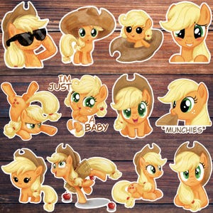 May include: A collection of twelve die-cut stickers featuring a yellow pony character with blonde hair and green eyes in various poses, including wearing a brown cowboy hat, sunglasses, and holding apples, with text reading I'M JUST A BABY and *MUNCHIES*.