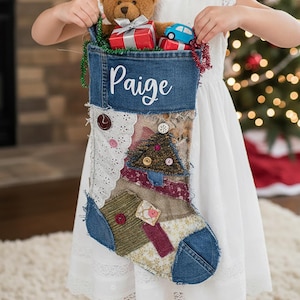 May include: A denim Christmas stocking with the name "Paige" embroidered on the cuff. The stocking is filled with a teddy bear, wrapped gifts, and a toy car. The stocking has a patchwork design with lace and fabric accents.