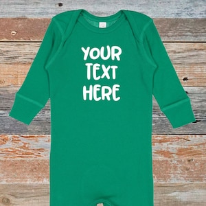 May include: A green long-sleeved baby onesie with the text "YOUR TEXT HERE" in white.
