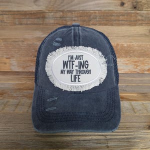Gorra de camionero sarcástica y divertida: ¡¿Qué demonios me pasa en la vida?! Gorra de béisbol con cola de caballo desgastada.