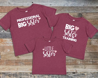 Koszulka z ogłoszeniem „Starsza siostra”: Koszulka z ogłoszeniem „Profesjonalista w szkoleniu” ukazująca rodzeństwo