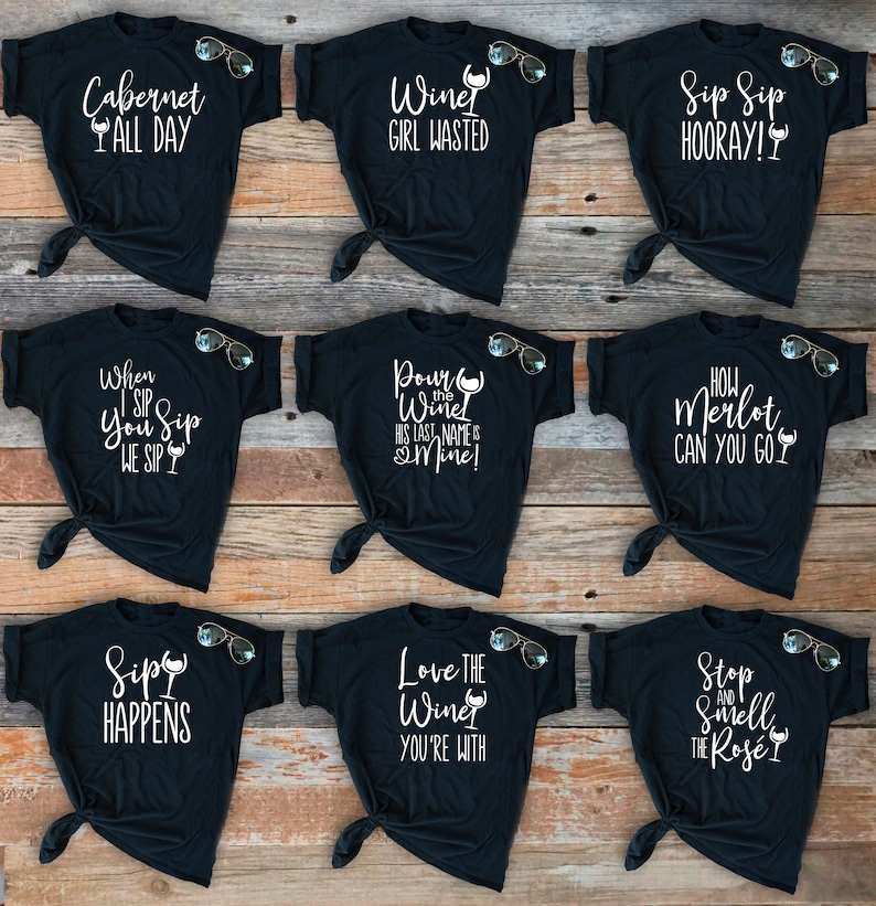 May include: Nine black t-shirts with white text and wine glass graphics. The shirts feature sayings like "Cabernet All Day", "Wine Girl Wasted", "Sip Sip Hooray!" and "Love the Wine You're With".