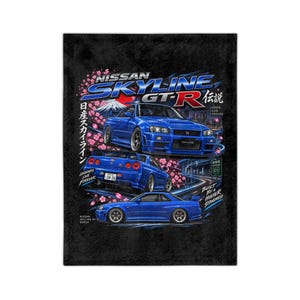 May include: A black rectangular textile featuring three blue Nissan Skyline GT-R cars in different angles. The design includes pink cherry blossoms, a mountain silhouette, and text reading Nissan Skyline GT-R, Japan Icon Forever, and Legends Live Forever.