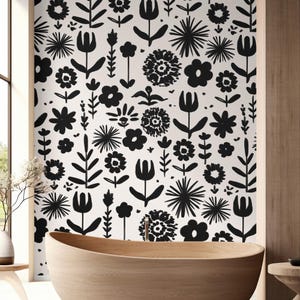 May include: A black and white floral wallpaper pattern adorns a bathroom wall. The design features various stylized flowers and leaves. A wooden bathtub is in the foreground, adding a natural element to the space. The room has a modern, minimalist aesthetic.