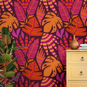 May include: A vibrant, repeating pattern of stylized tropical leaves in shades of orange, pink, and purple against a dark background. The design includes large monstera leaves and other leaf shapes, creating a bold, colorful botanical theme.