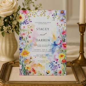 May include: A wedding invitation featuring a watercolor design with colorful flowers and text. The invitation includes the names "Stacey and Darren", event details, and the venue, The Tulip Garden, Central Park, New York.