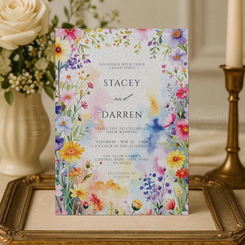 May include: A wedding invitation featuring a watercolor design with colorful flowers and text. The invitation includes the names "Stacey and Darren", event details, and the venue, The Tulip Garden, Central Park, New York.