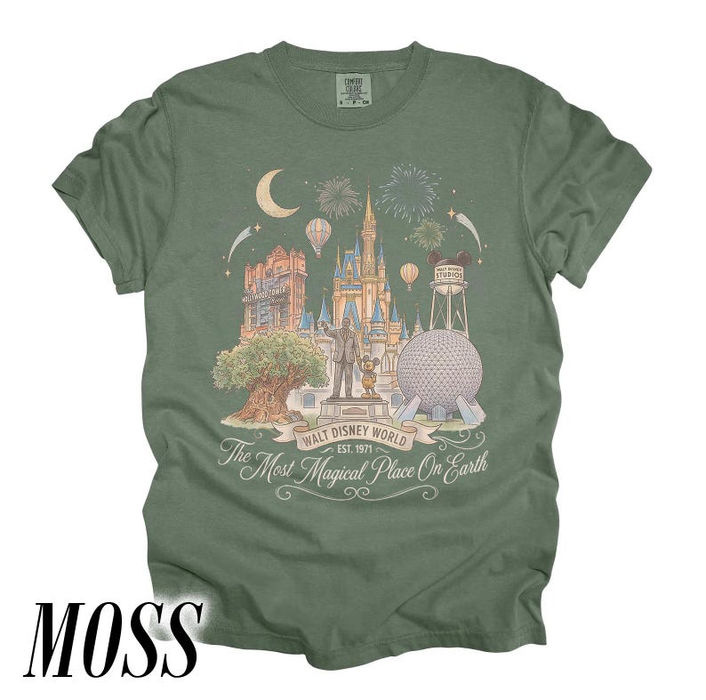Pode incluir: Camiseta verde musgo com uma ilustra&ccedil;&atilde;o detalhada dos marcos da Walt Disney World, incluindo o Castelo da Cinderela e a Spaceship Earth. O texto diz "Walt Disney World Est. 1971" e "The Most Magical Place On Earth."