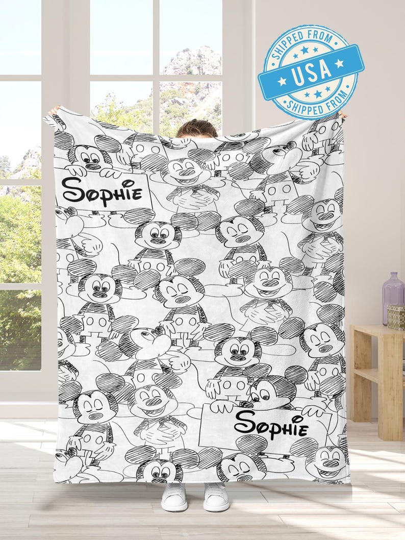 Puede incluir: Una taza de cer&aacute;mica blanca con un asa negra y el texto "But First, Coffee" en negrita negra. La taza se encuentra sobre un fondo borroso, sugiriendo un ambiente acogedor.