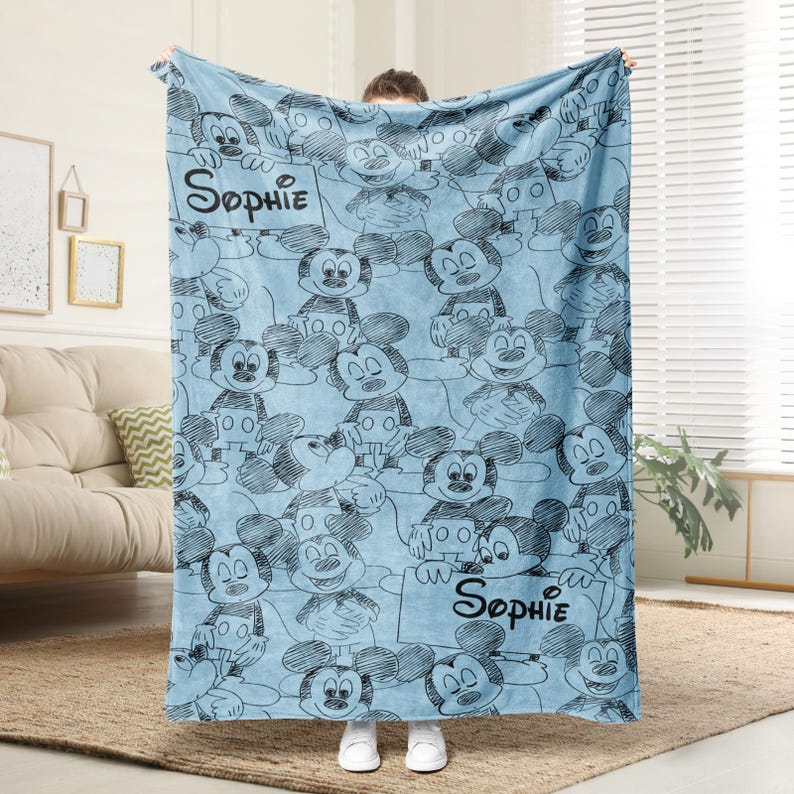 Puede incluir: Una taza de cer&aacute;mica blanca con un asa negra y el texto "But First, Coffee" en negrita negra. La taza est&aacute; sobre un fondo borroso. La taza mide aproximadamente 10 cm de altura.