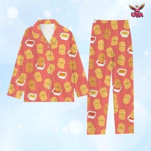 Puede incluir: Conjunto de pijama de dos piezas de color coral con un estampado repetido de nuggets de pollo sonrientes y salsas. La parte superior de manga larga tiene botones y los pantalones tienen cintura el&aacute;stica.