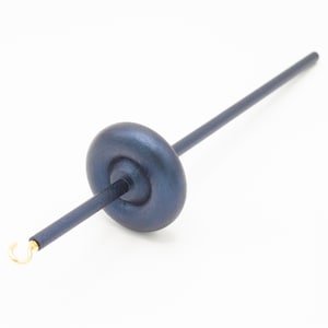 May include: A dark blue wooden drop spindle featuring a smooth, rounded whorl positioned along a straight shaft. The tool includes a small, metallic gold-colored hook at one end, designed for fiber spinning tasks with a sleek, uniform finish.