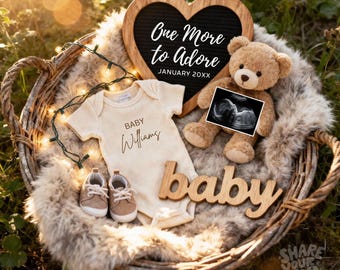 Op de afbeelding: Een rieten mand bevat een beige romper, babyschoentjes en een teddybeer met een echo. Een houten hartvormig bord leest "One More to Adore" en "January 20XX". Het woord "baby" is geschreven in houten letters.