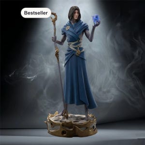 May include: A detailed figurine of a character in a flowing blue robe, holding a staff and a glowing blue cube. The figure stands on a gold-coloured base with a spiky design. The word "Bestseller" is in a white oval in the upper left corner.