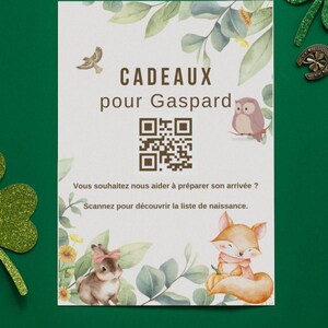 Peut inclure: Une carte blanche avec le texte "CADEAUX pour Gaspard" et un code QR, entourée d'illustrations d'oiseau, de hibou, de lapin et de renard. La carte est décorée de feuilles et de fleurs vertes.